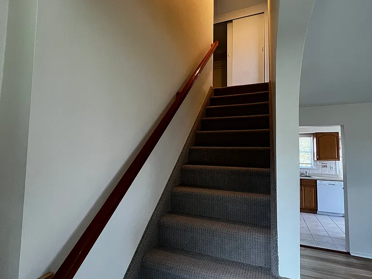 Stairs to upstairs Bedrooms with new carpet. Full length closet at top of stairs with smoke detector .