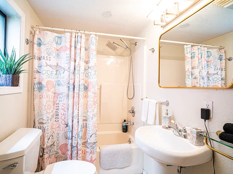 A clean, full-sized bathroom stocked with body soap, shampoo and conditioner.