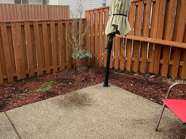 Enclosed rear patio with installed umbrella.