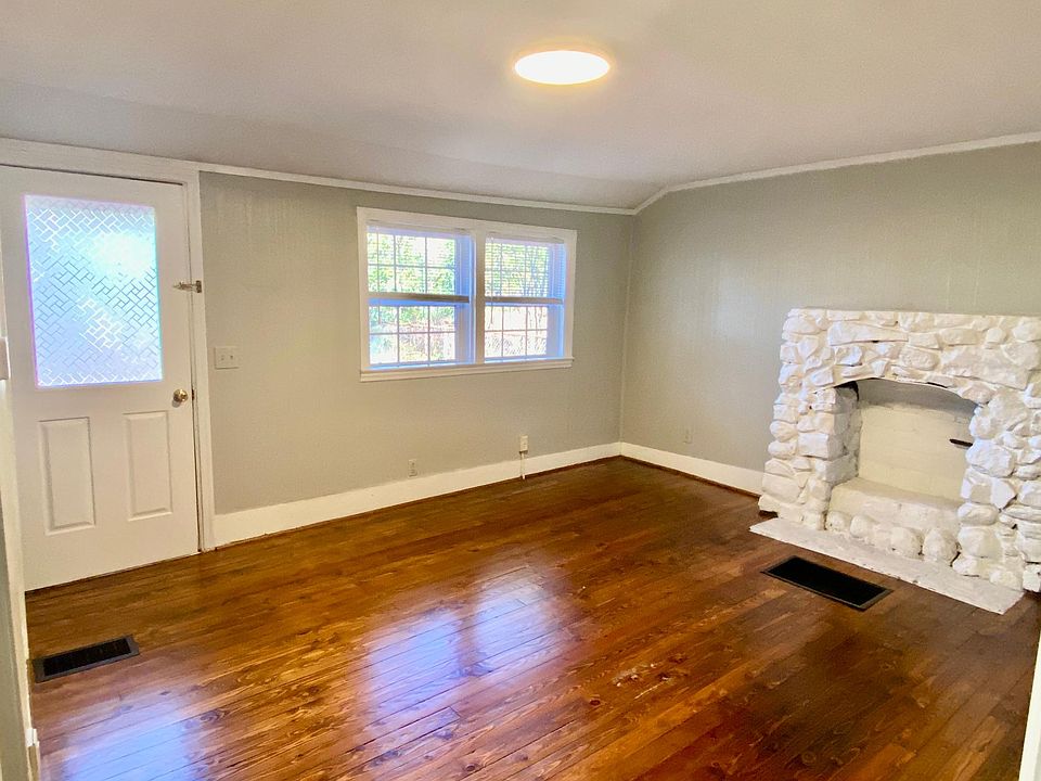 Living room. Fireplace is not usable. Mini blinds and curtain rods (not pictured) are included.