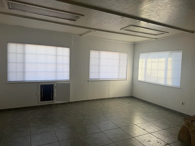 The large windows are equipped with blinds for added privacy, and pet owners will appreciate the convenient doggy door, providing easy access for their furry companions.