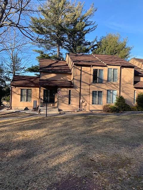 front of unit - two floors with green area in front and trees all around. Third bedroom is on the jutting out area to the left. Living room as you walk in. Kitchen and dining room are to the left.