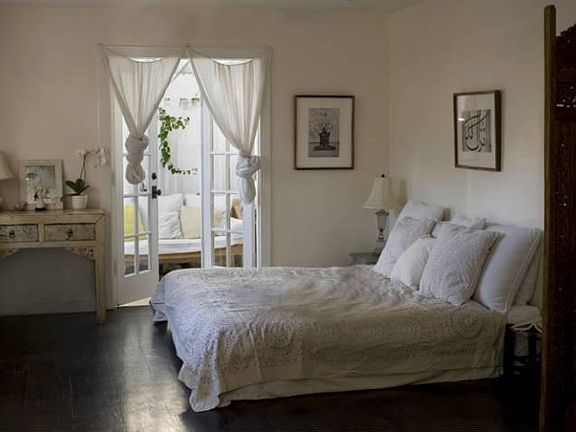 Large master bedroom with hardwood floors and French doors leading to covered patio with Balinese daybed... perfect for reading, writing, early morning meditation or simply daydreaming...