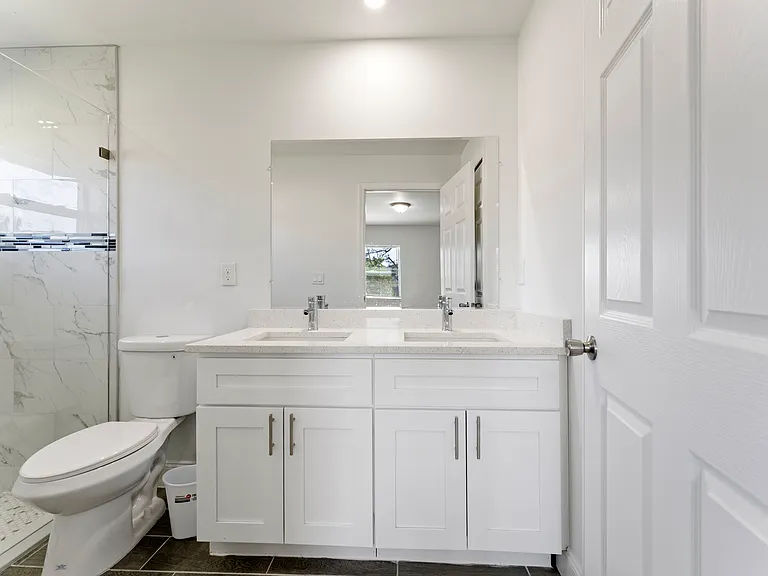 Master bathroom with his/her sinks and walk-in shower