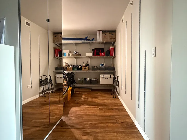 Large storage/pantry area with extensive shelving and mirrored shoe/storage cabinet