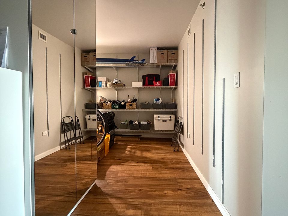 Large storage/pantry area with extensive shelving and mirrored shoe/storage cabinet