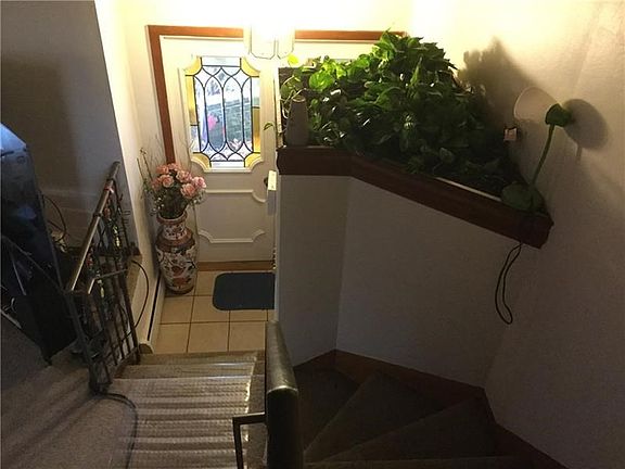 Welcoming entryway with leaded glass doors leading to the living room and to the ground level family room.