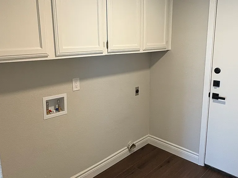 Utility room with extra cabinet storage and hook ups for washer and dryer