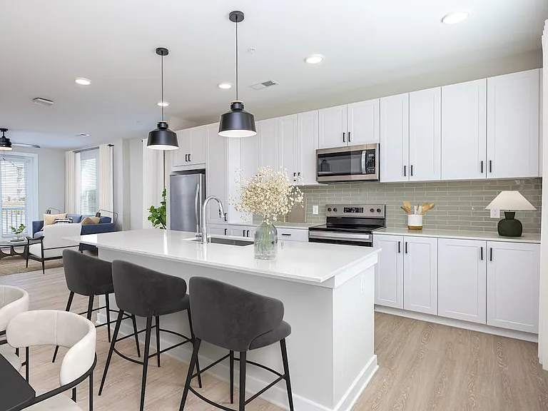 Townhome kitchen with white cabinetry, stainless steel appliances, and quartz countertops