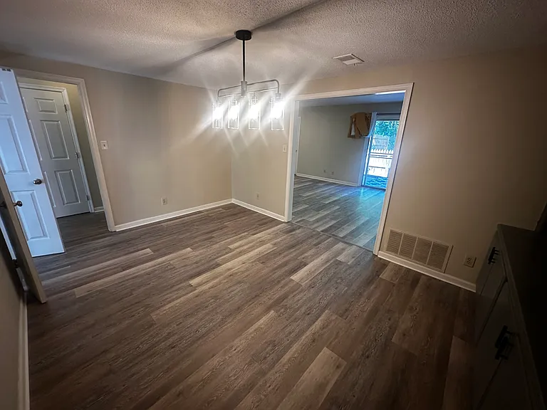 Spacious dining room featuring a wet bar, custom built-ins, and brand-new flooring.
