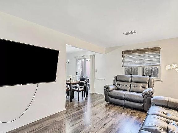 Living room with looking toward the dining area and backyard. All new flooring! Looks stunning!
