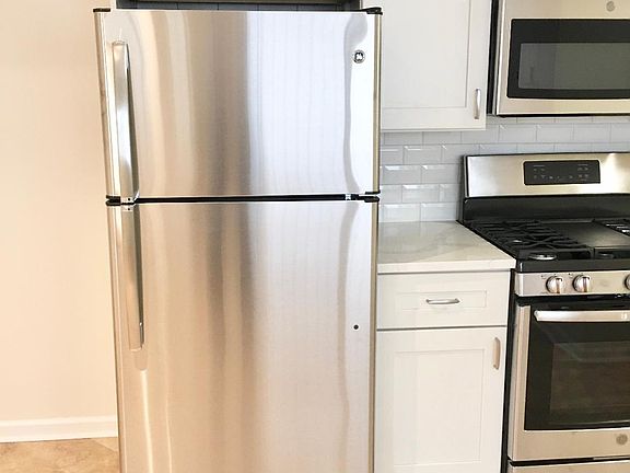 kitchen after renovations - new cabinets - new back splash - new stainless steel appliances - stove - refrigerator, microwave and dishwasher