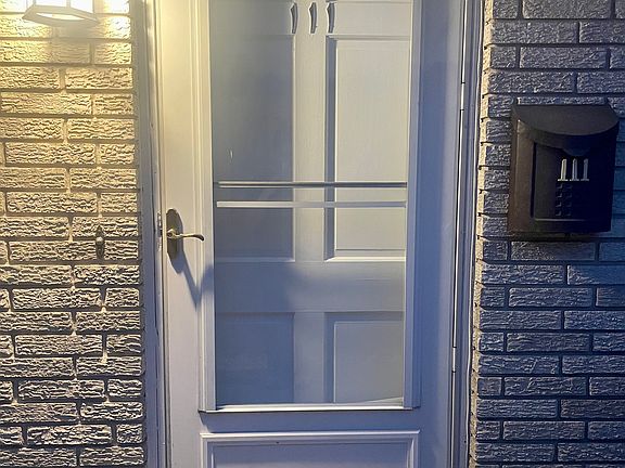 Welcoming front entrance featuring a sturdy storm door for added security and weather protection.