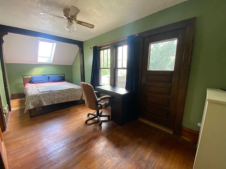 Upper-level back bedroom with skylight and private balcony access