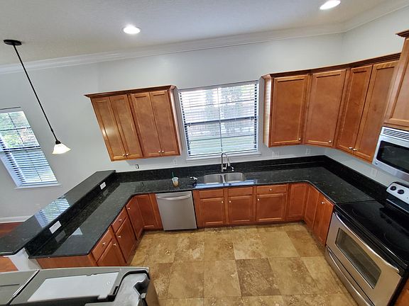 Kitchen has travertine marble flooring.