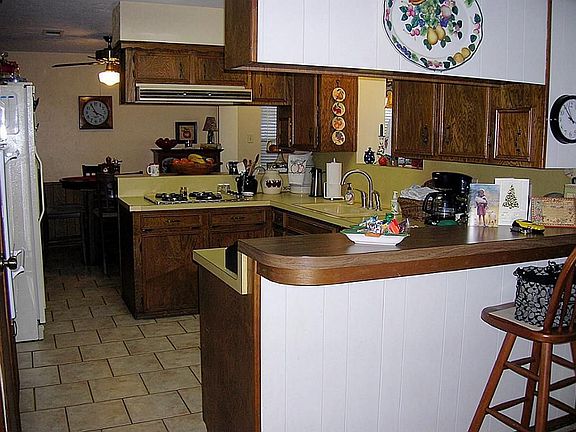 Comfortable kitchen has pass-thru to gameroom and double breakfast bars