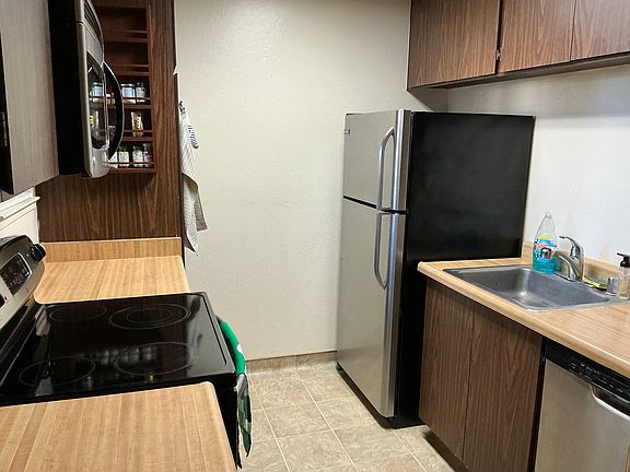 Kitchen with refrigerator, dishwasher and electric stovetop/oven. Built in microwave above oven.