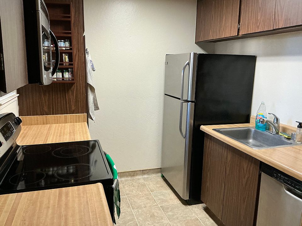 Kitchen with refrigerator, dishwasher and electric stovetop/oven. Built in microwave above oven.