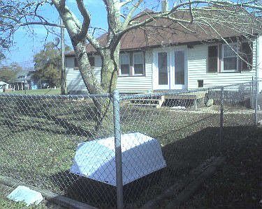 Back of home with partially fenced yard