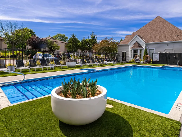 Relax and unwind at our serene poolside area, featuring comfortable lounge chairs, lush greenery, and a tranquil atmosphere perfect for a refreshing swim or sunbathing.