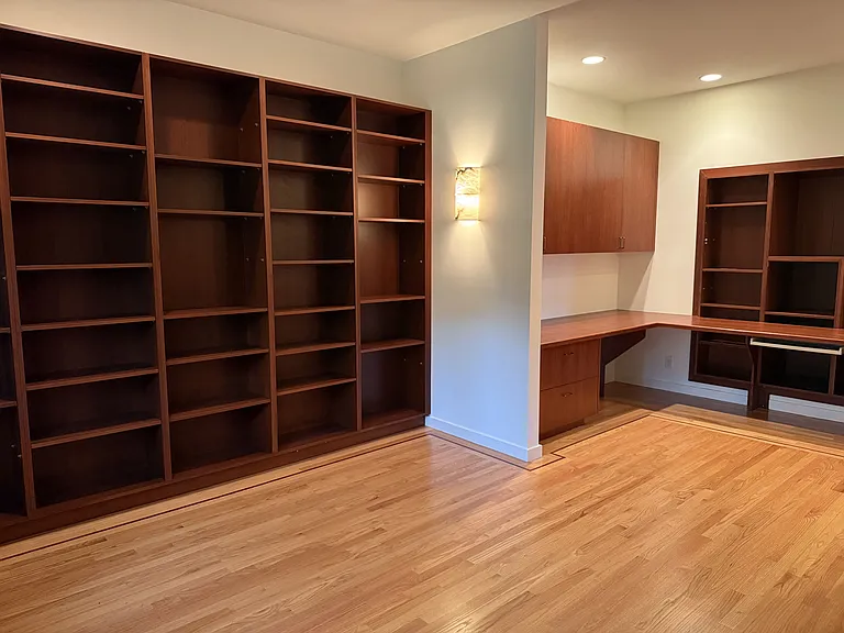 Private office features a built-in wall desk and library cabinetry.