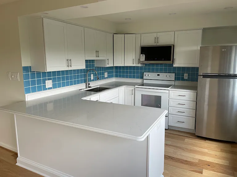 Kitchen with new cabinets and quartz counters.
