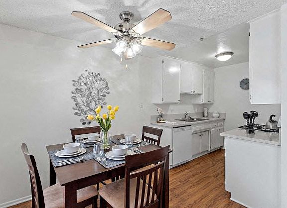 Modern and bright dining room and the kitchen at the Ridgeview Apartment with plank flooring