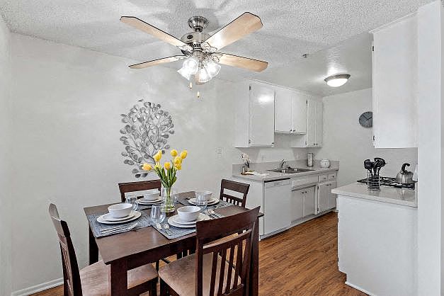 Modern and bright dining room and the kitchen at the Ridgeview Apartment with plank flooring