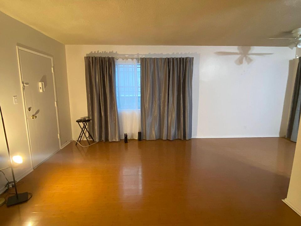 Large living room and foyer with wood floors.