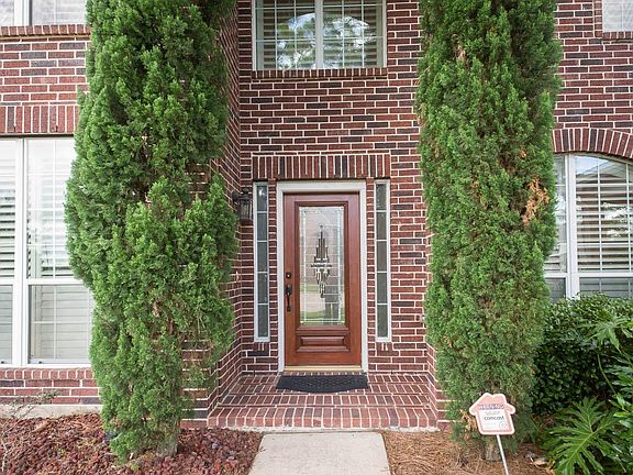Towering cypress trees frame this leaded glass door.
