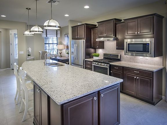 Model Representation Thoughtfully designed kitchen with decorative tile backsplash and stainless ap