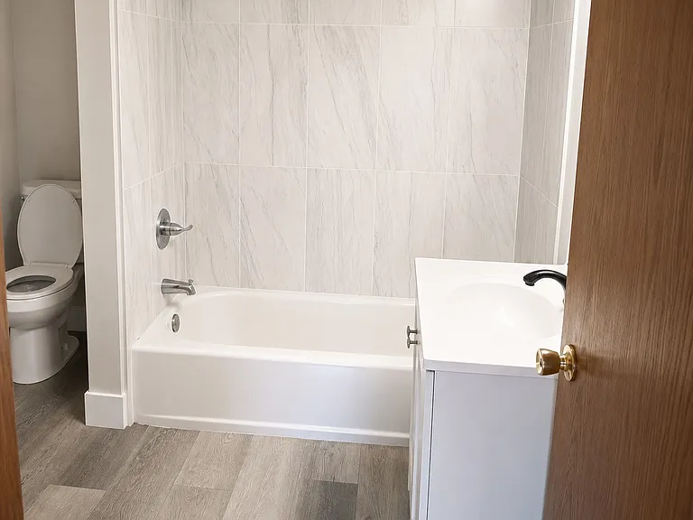 Updated bathroom featuring a modern vanity, tiled tub and shower surround, contemporary fixtures, and easy-care finishes. Washer Dryer hook Up in unit.
