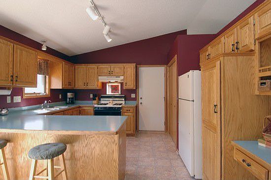 Spacious kitchen features vaulted ceiling with track lighting, a breakfast bar