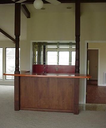 Bar in den has shelves, counters, and storage cabinets.