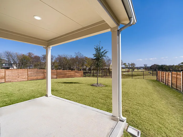 A covered patio opens to a fenced backyard, offering a private outdoor space suited for everyday moments and time spent at home.