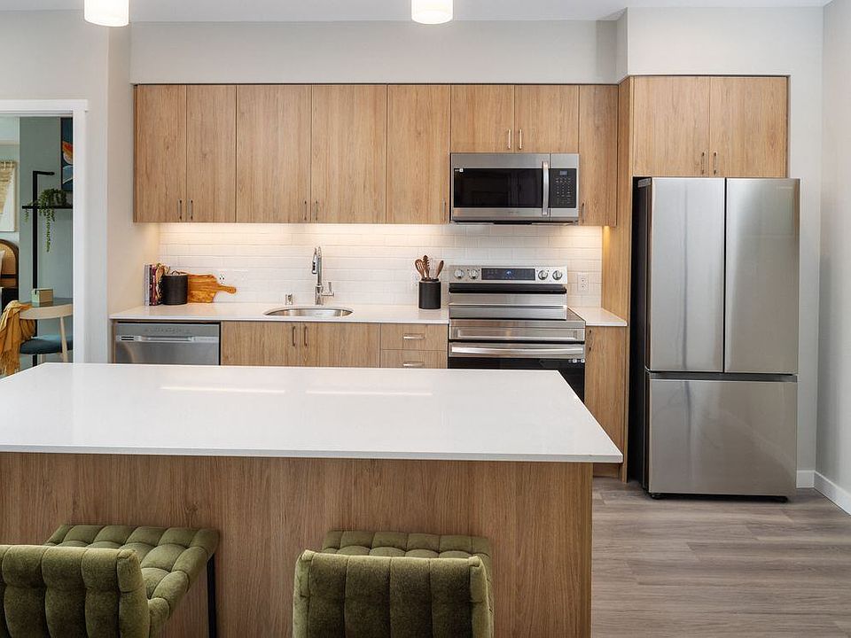 Kitchen with oak cabinetry, stainless steel appliances, granite countertops, and hard surface flooring