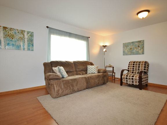 The living room features durable laminate floor and lightens up the room.