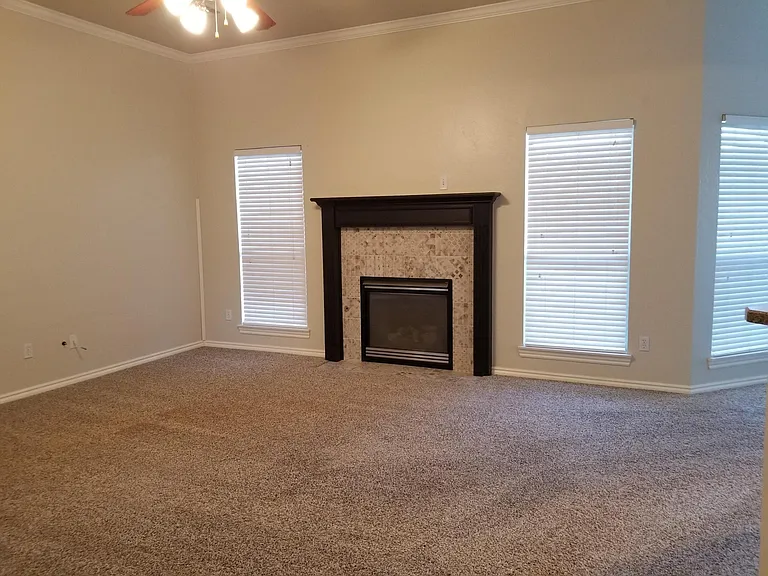 Living room with gas fireplace and large windows. Electrical outlet and cable have been added so TV can be mounted above mantel.