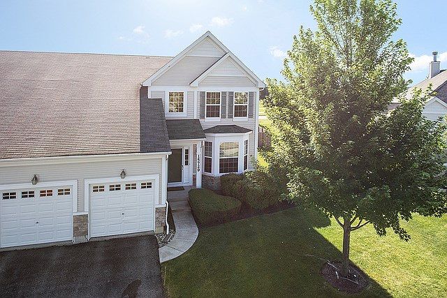 1/4 up stonework decorates this tranquil duplex front, side and back.  Covered front porch entry is 