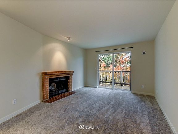Living room with cozy, wood-burning fireplace and deck.
