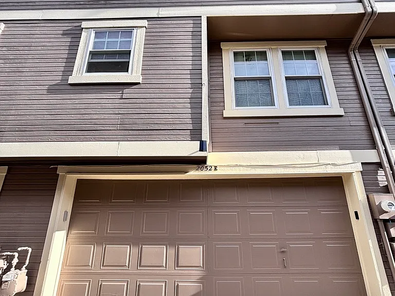Rear view with attached 2-car garage and multi-level layout