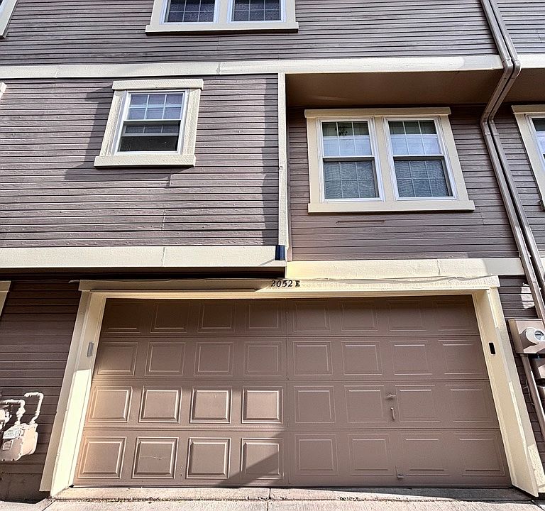 Rear view of home showing 2-car garage entrance and 1st and 2nd floor windows
