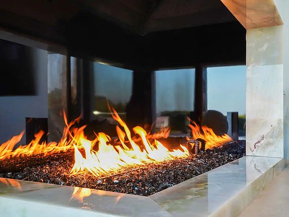 A striking green onyx fireplace with brass detailing, the centerpiece of the living area.