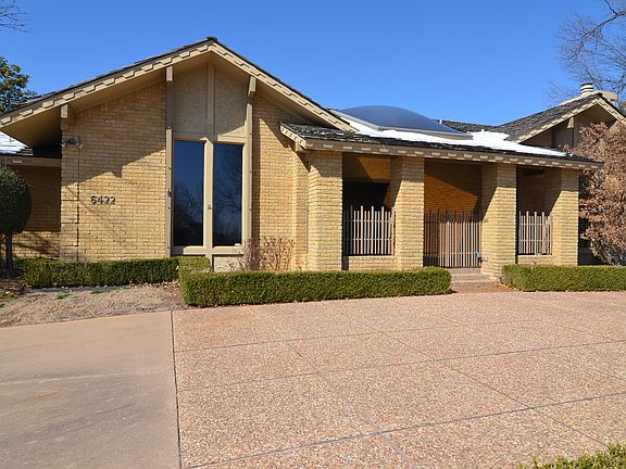 Front entrance features a large covered porch with skylight and rod iron gate.