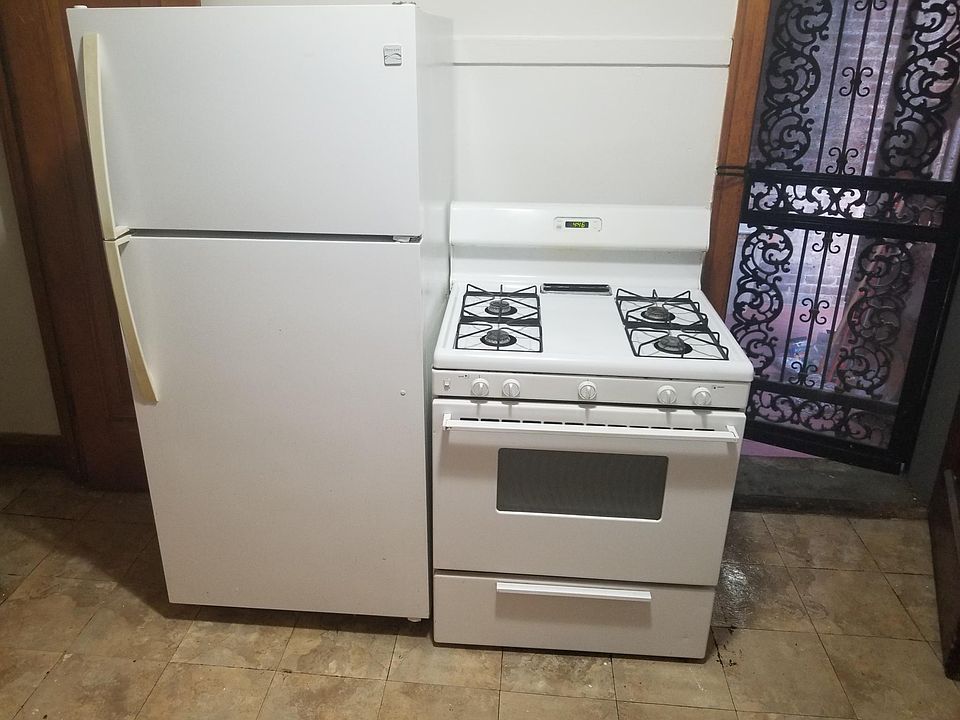 Kitchen Appliances and rear door to porch. security gate