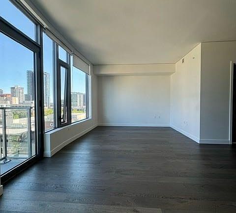 big open living room den, cable ports and wifi outlets are provided and can install through building. Sun drenched wall of windows with nice view of Amazon highrises facing towards wall st.