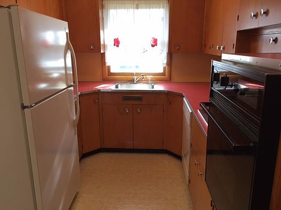 Electric stove and oven.  Original birch cabinets.