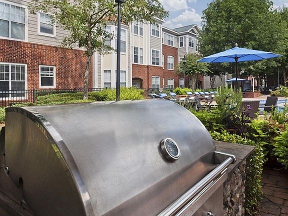 Professional grills near pool with seating, lighting and a f