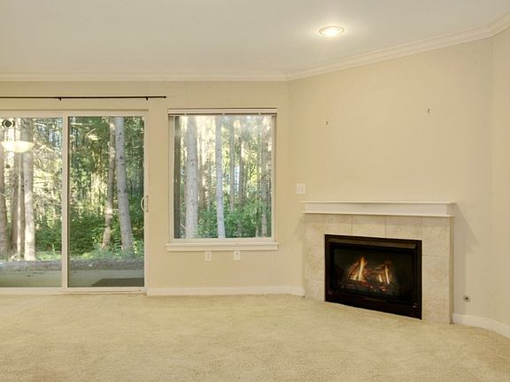 Living room has gas fireplace & sliders to private patio.