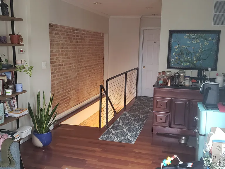 Third story common area looking towards bedroom and staircase leading to second floor.